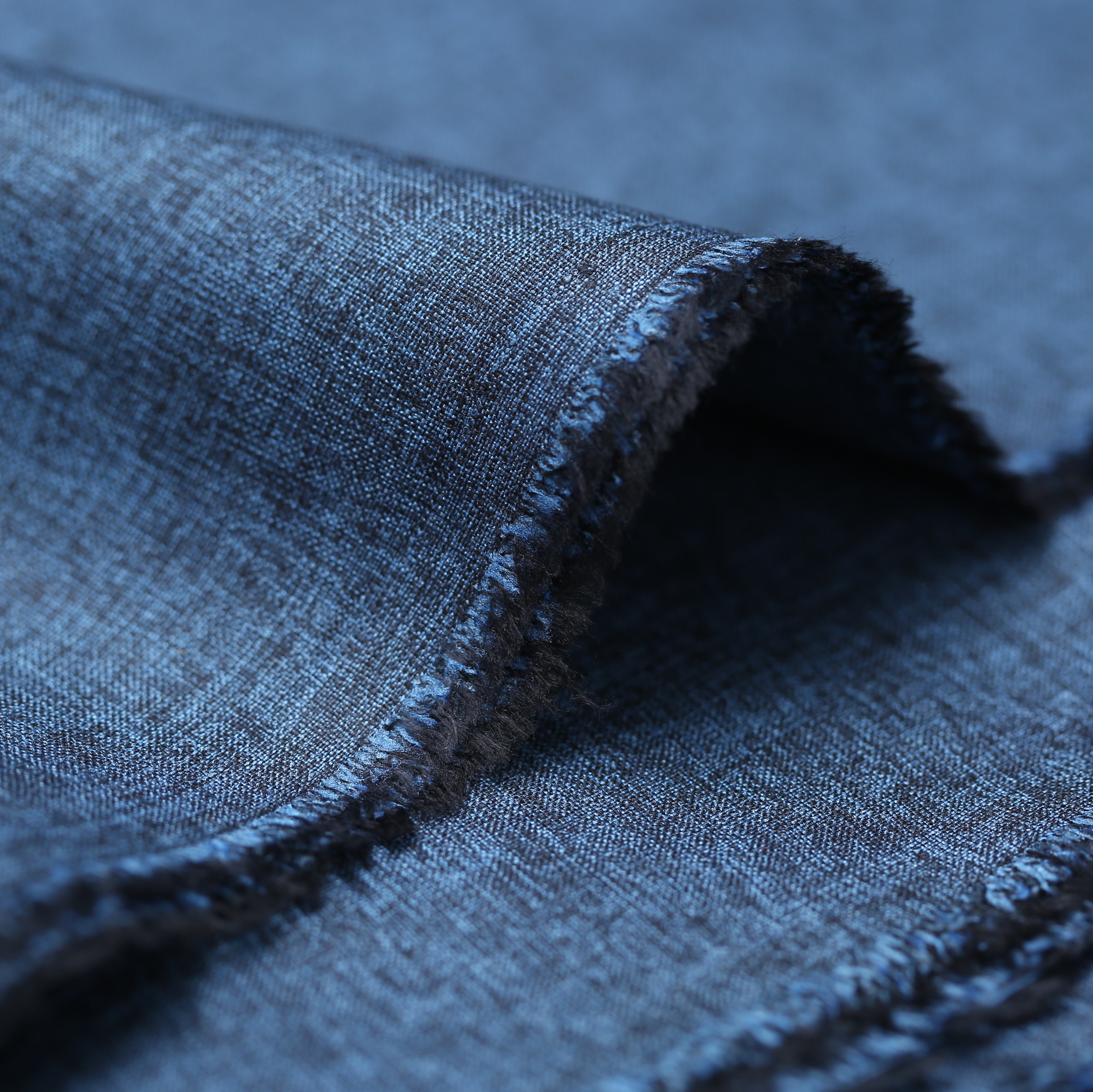 Dark blue denim fabric with folded edge and visible texture